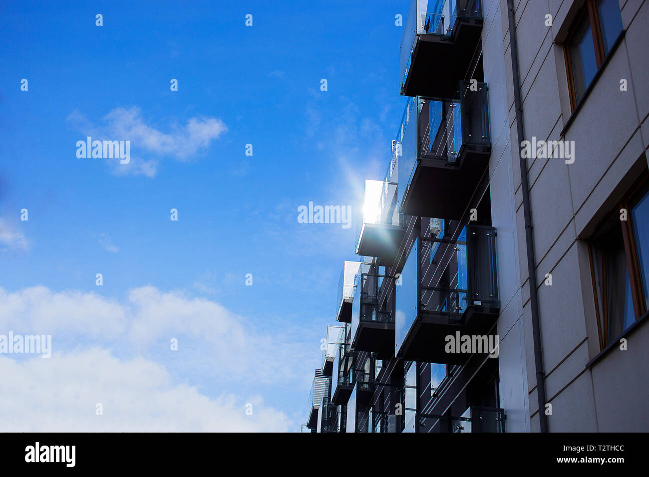 Neu gebaute Wohnungen mit sauberem Glas Balkone glänzen in der Sonne am Himmel Hintergrund Stockfoto