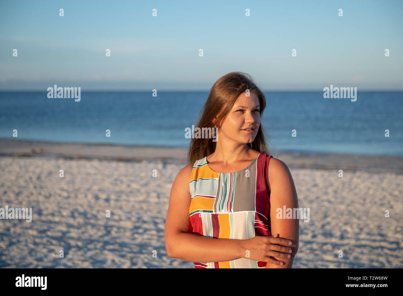 Junge Frau trägt ein Kleid denken und weg schauen am Strand Stockfoto