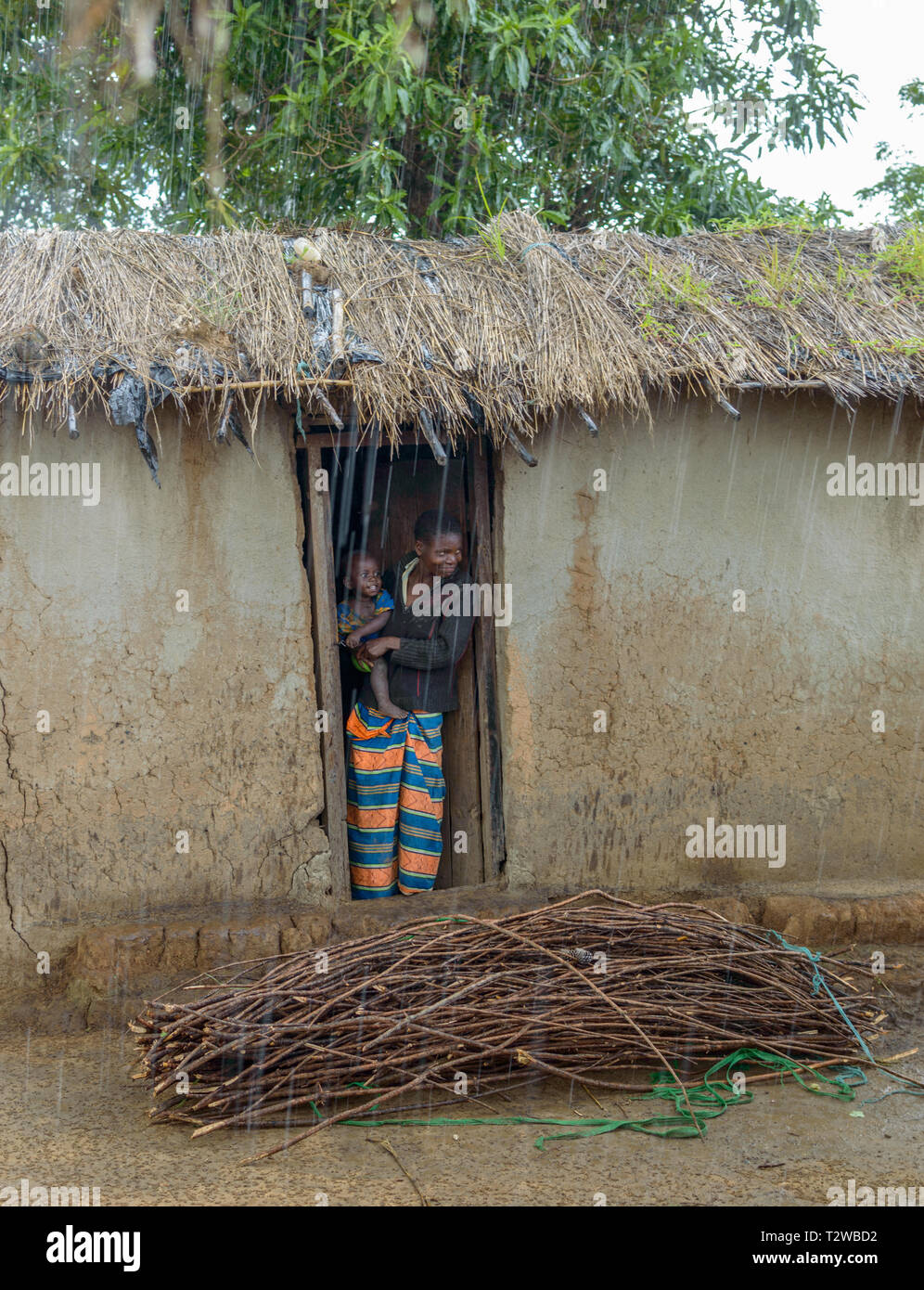 Frau Und Kind Von Regen In Der Tur Ihrer Lehmhutte In Einem Dorf In Malawi Verstecken Stockfotografie Alamy