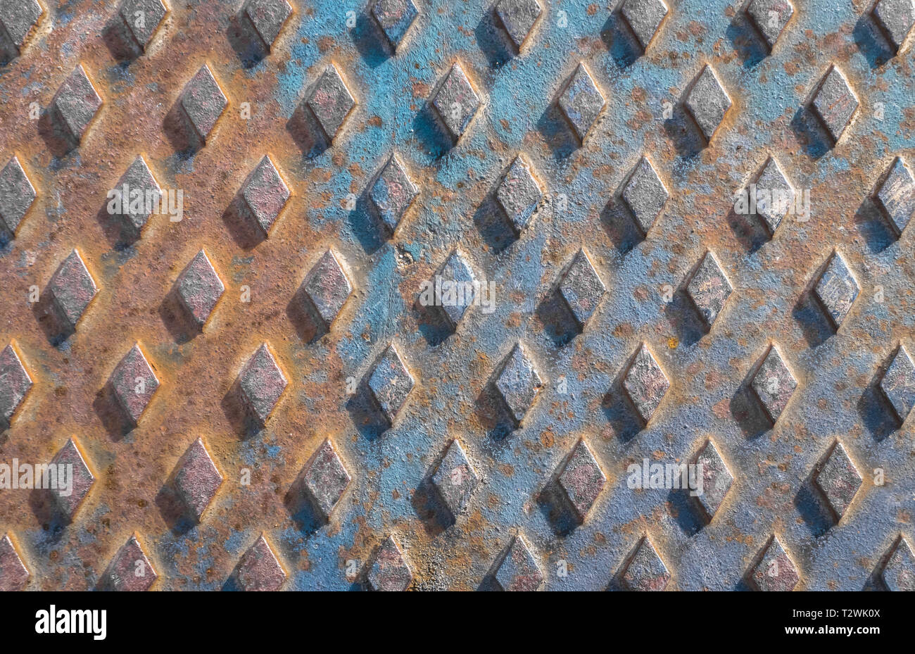 Alten rostigen Kanaldeckel Hintergrund mit Rautenmuster. Stockfoto