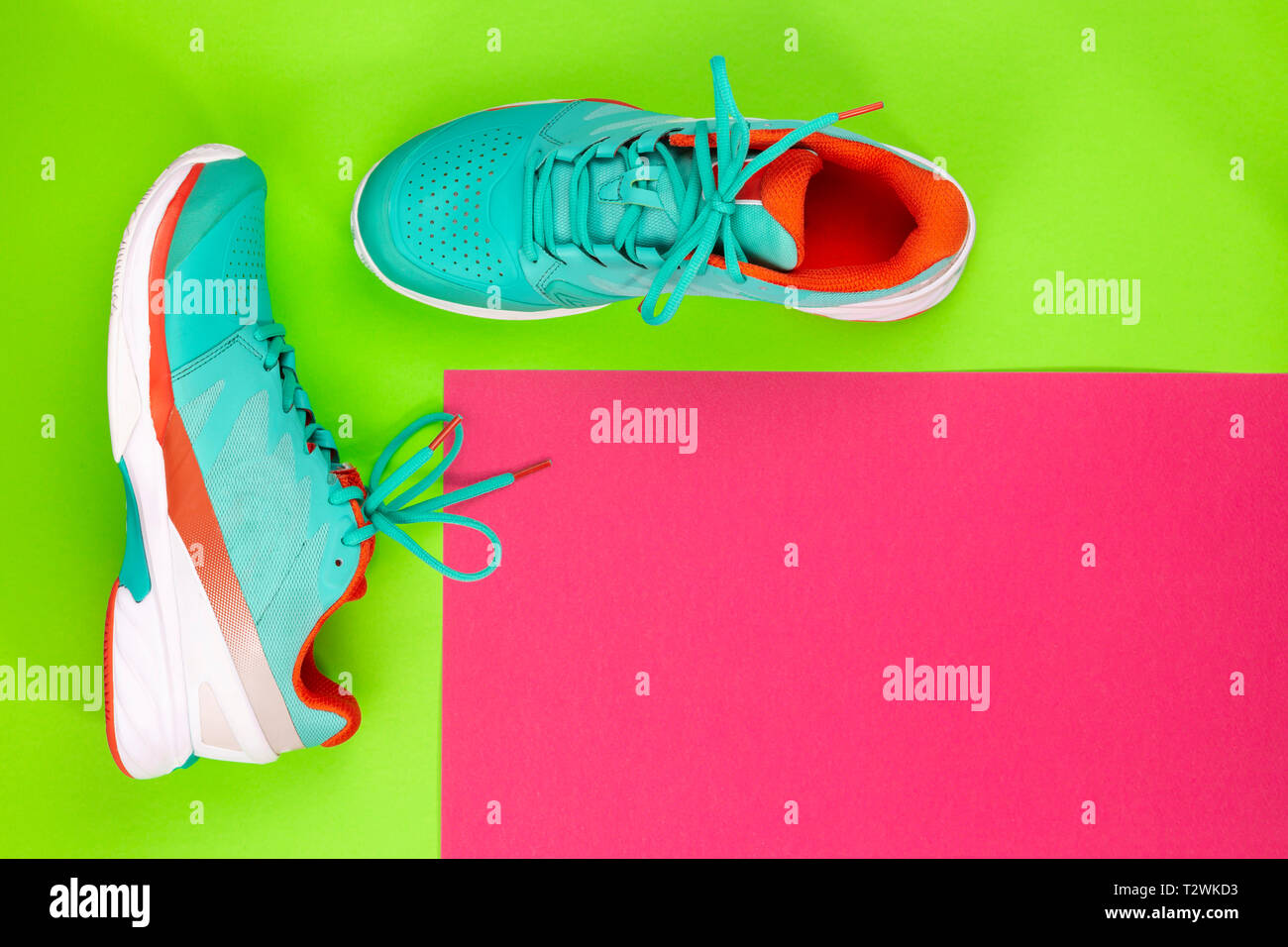 Rot, hellblau, weiß, Paar neue Tennisschuhe im Studio Schuß über grün, lila Hintergrund. Direkt von oben. Stockfoto