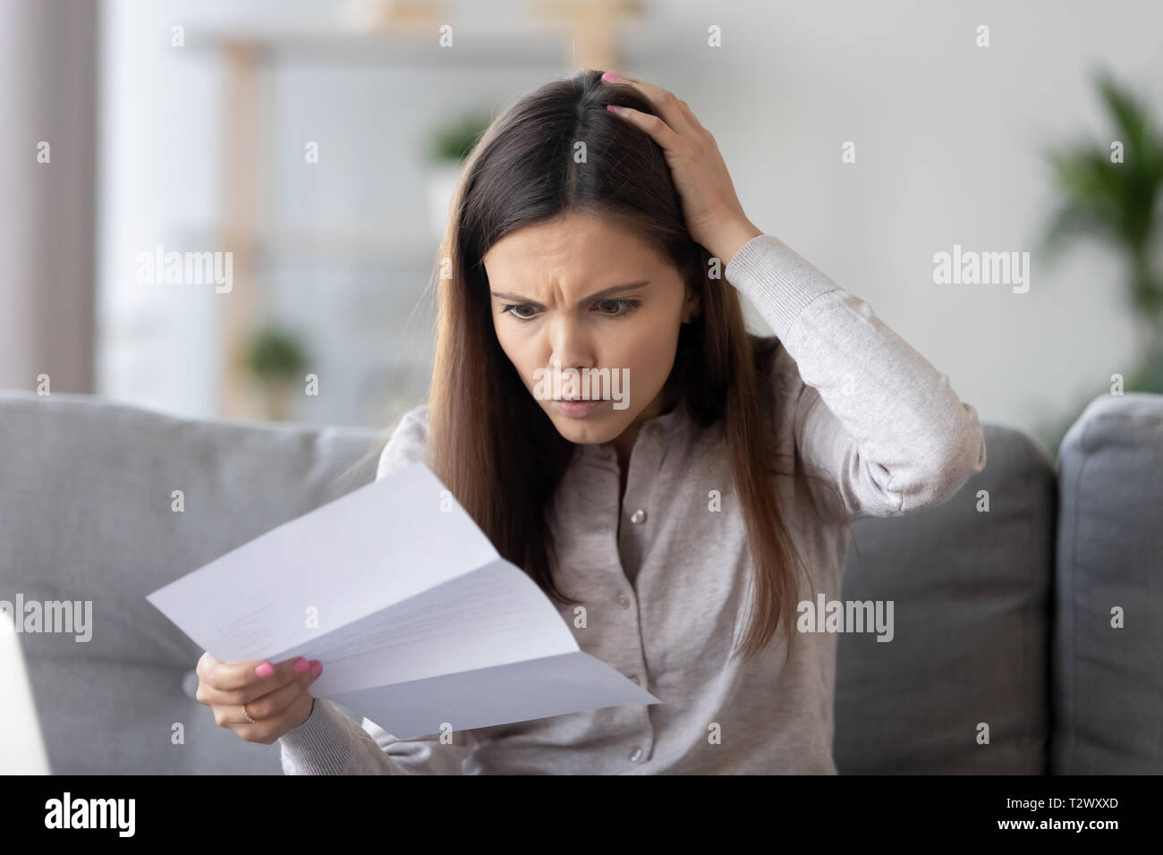 Besorgt der frustrierten Frau Lesen Schreiben durch schlechte Nachrichten schockiert Stockfoto