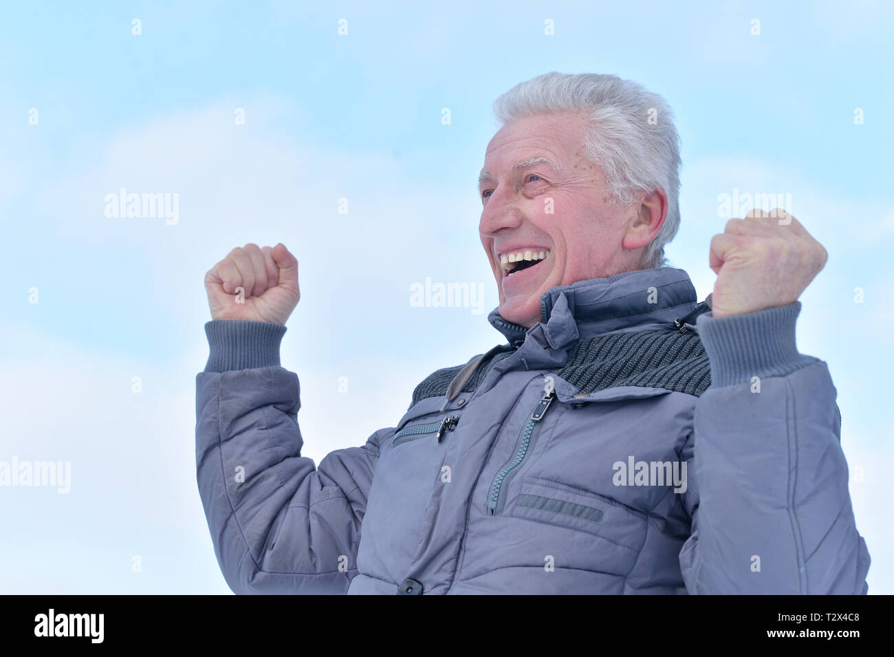 Portrait von lächelnden älteren Mann mit erhobener Faust stehen im Freien im Winter Stockfoto