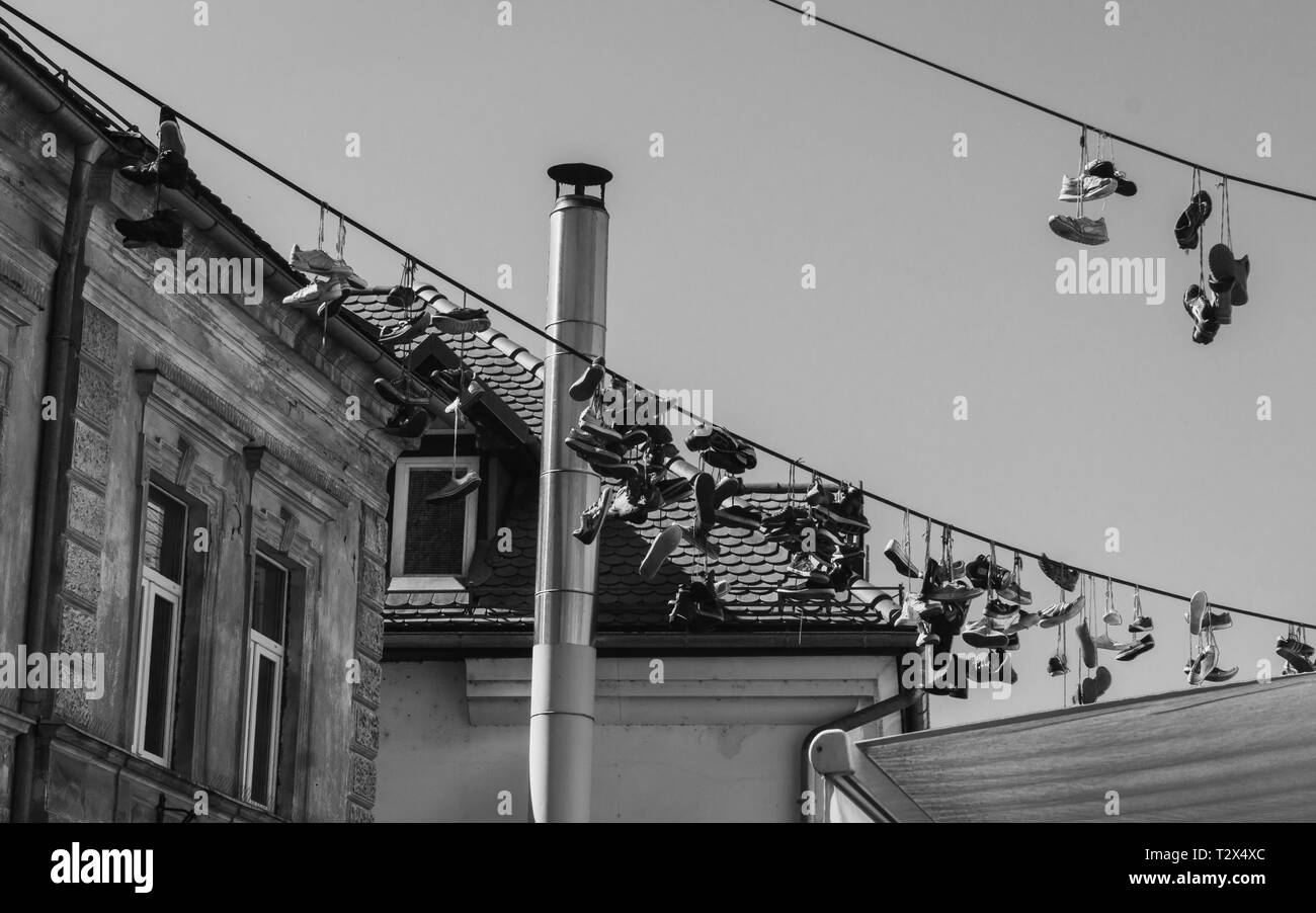 Schwarz-weiß Foto von Schuhe auf einem Draht, der in Ljubljana, Slowenien hängen Stockfoto