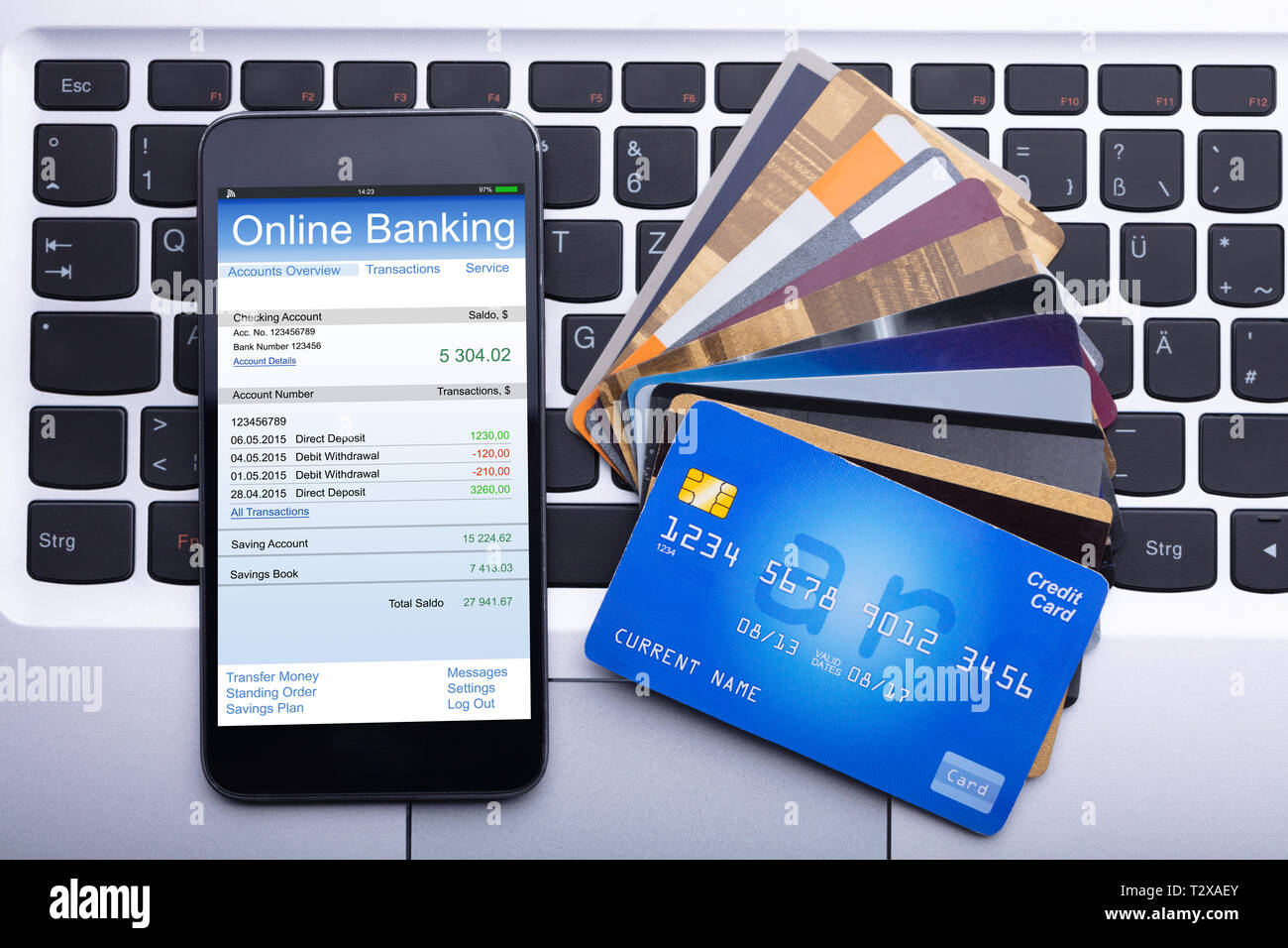 Einen erhöhten Blick auf Mobilephone mit Online Banking App und Kreditkarten auf Laptop Tastatur Stockfoto