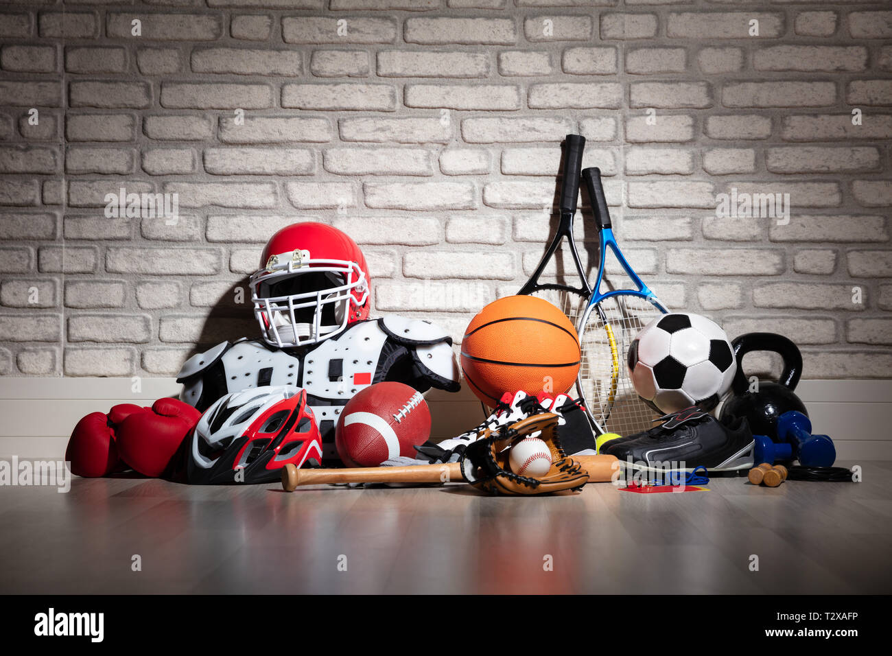 Verschiedene Sport Ausrüstung auf dem Boden vor der Mauer Stockfoto