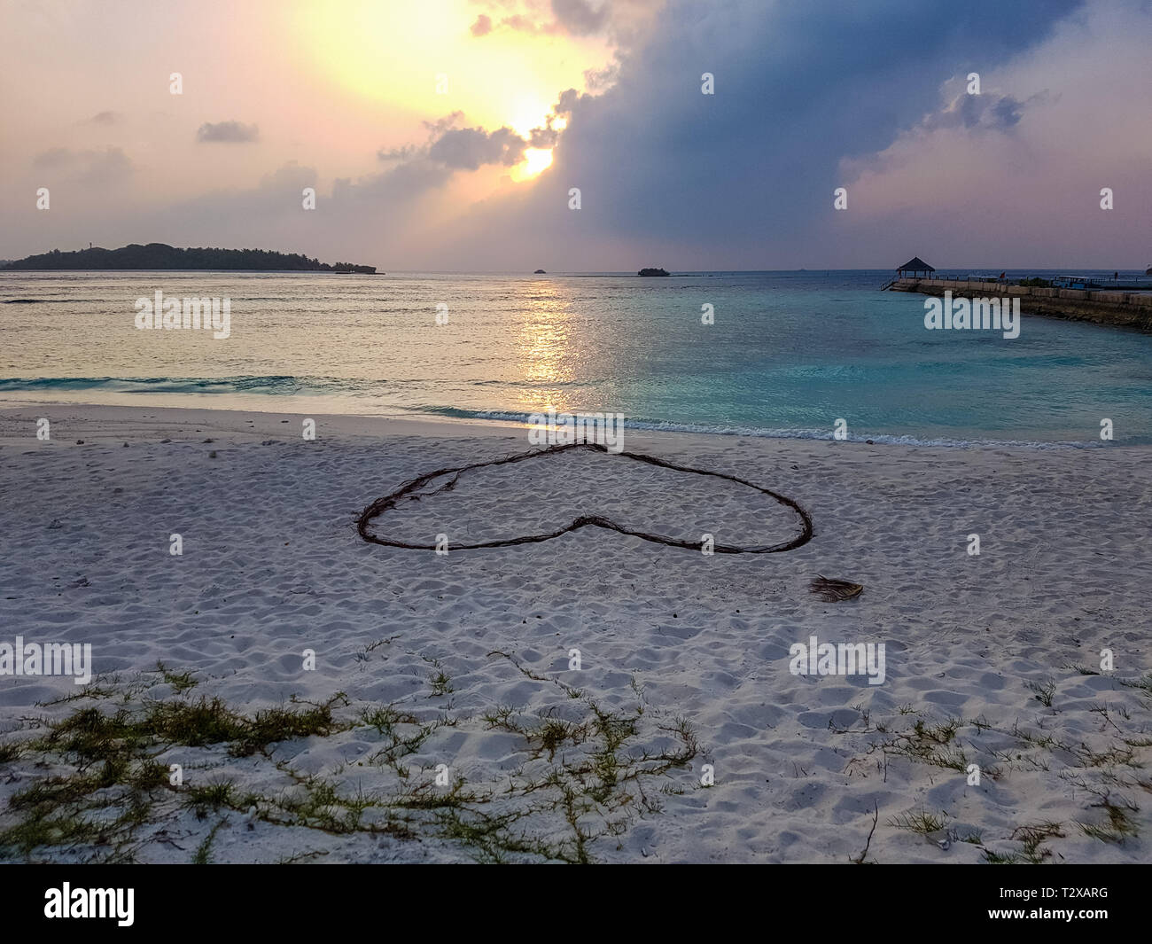 Romantische Herz auf Sand an einem tropischen Strand. Klare türkisfarbene Meer. Malediven Inseln. Stockfoto