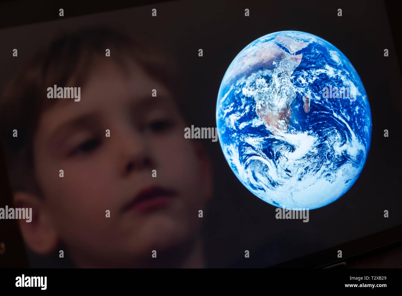 Reflektion von einem Jungen auf der Erde auf einem Tablet-PC Stockfoto