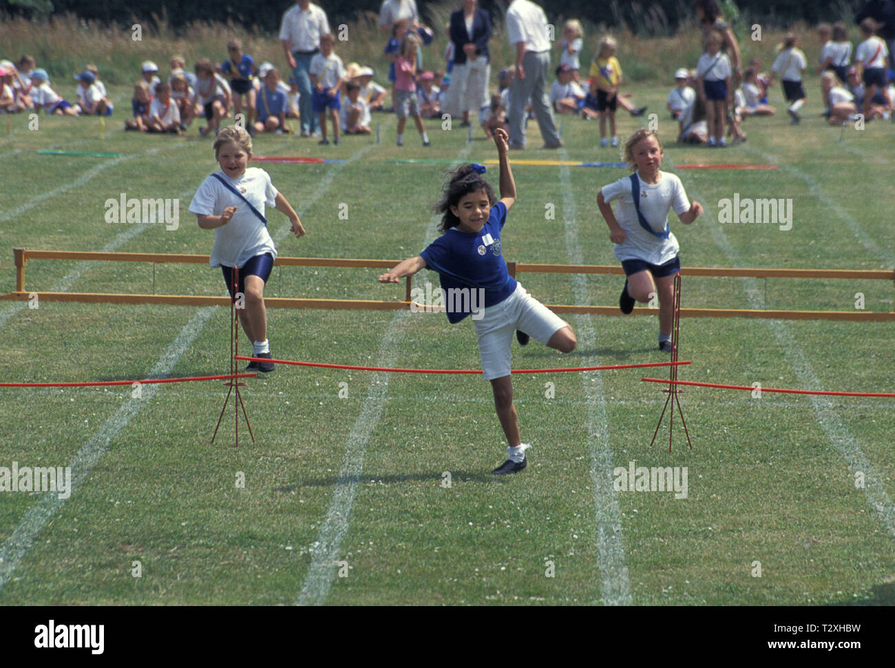 Grundschule Kinder in Hurdle Race beim Sport Tag konkurrierenden Stockfoto