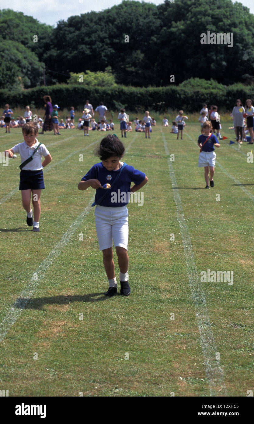Grundschule Mädchen im Ei und Löffel Rennen beim Sport Tag Stockfoto