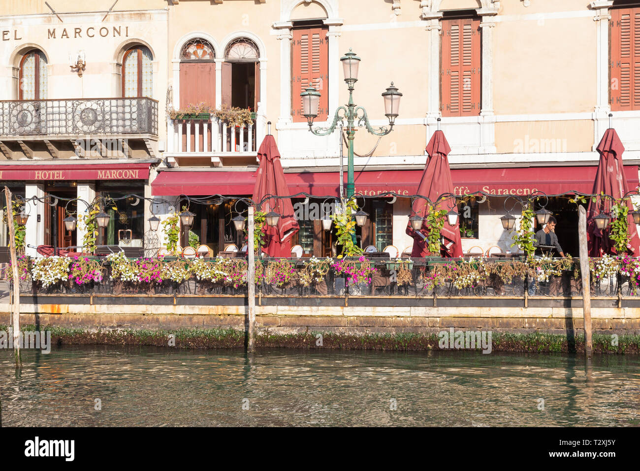 Ristorante Café Saraceno, Grand Canal, Riva del Vin, San Polo, Venedig, Venetien, Italien aus dem Wasser in den frühen Morgenstunden mit Kellner über Tabellen ou Stockfoto