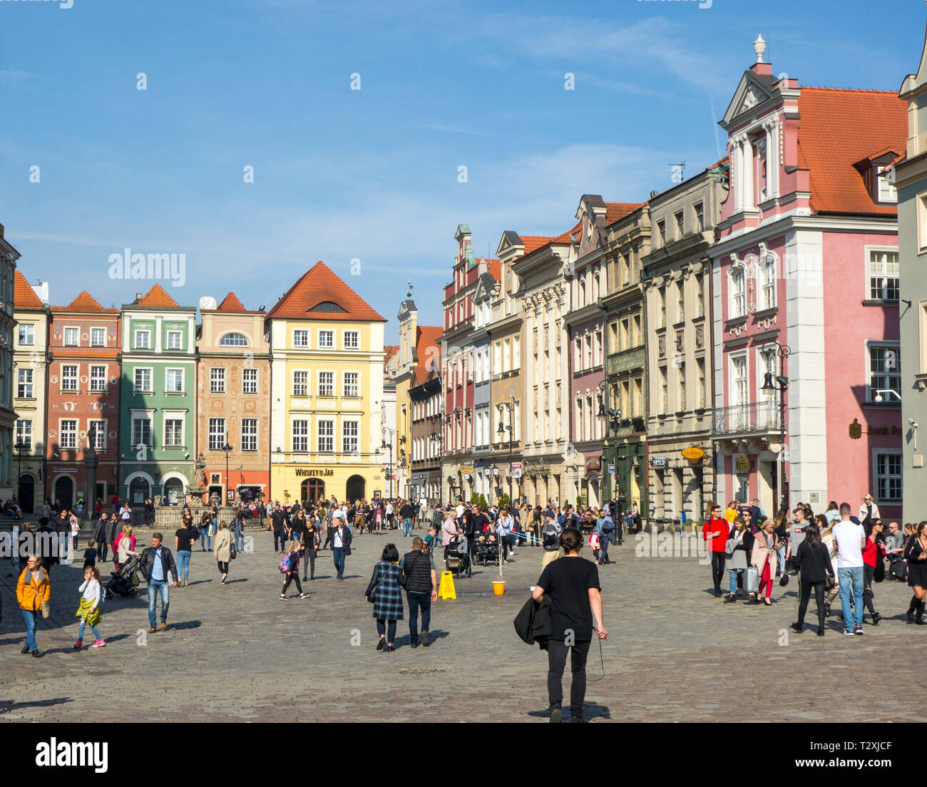 Menschen, Männer und Frauen, die in der Old Town Square in der polnischen Stadt Poznan Polen mit seinem bunten Häuser Restaurants und Cafes Stockfoto