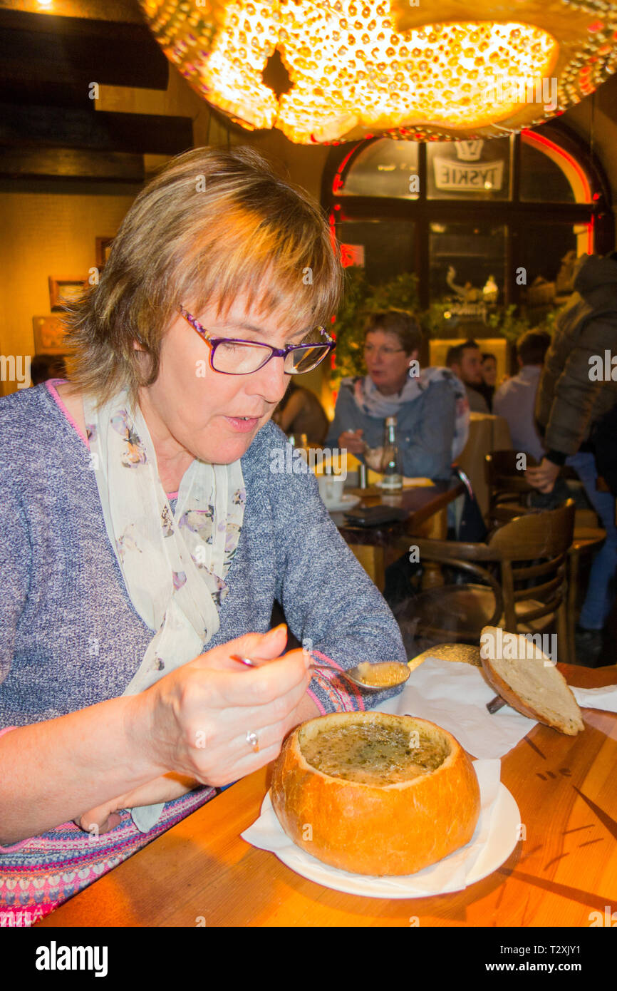 Frau essen Zurek eine polnische Roggen Suppe serviert in einem Brot Bowl, in einem Restaurant in der polnischen Stadt Poznan Stockfoto