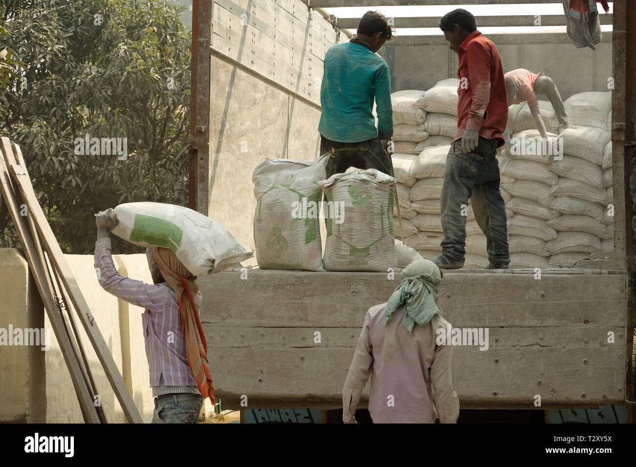 Eine Gruppe von Arbeiten sind Transport von Zement von der Rückseite eines Lkw Stockfoto