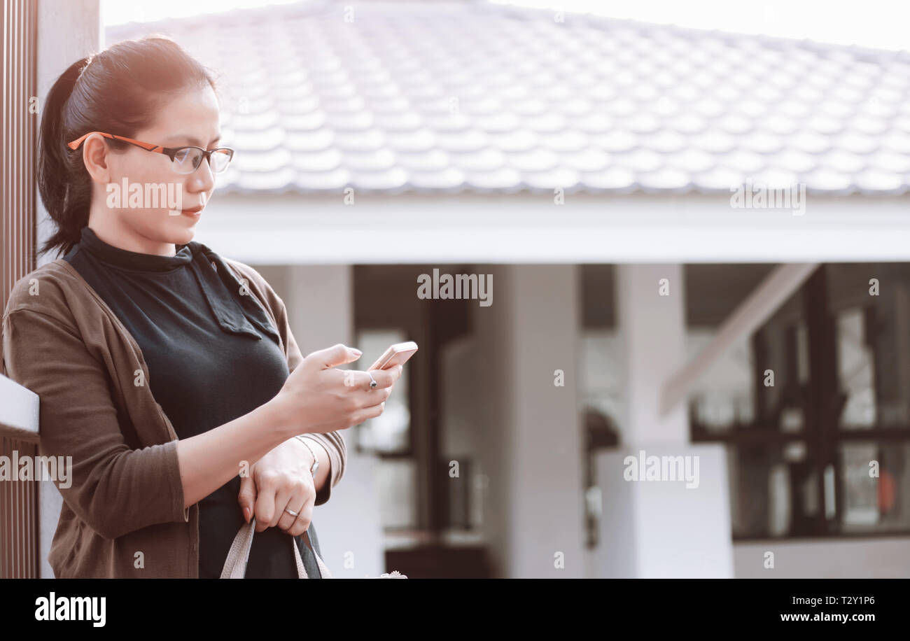 Frau mit Mobiltelefon am Bahnhof Stockfoto