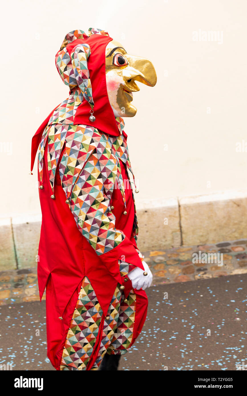 Rheinsprung, Basel, Schweiz - März 13., 2019. Porträt eines Karnevals Teilnehmer in rot Kostüm mit goldfarbenen Maske Stockfoto