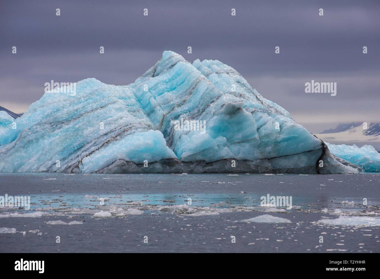 Schwebender Klumpen aus Eis vor einer riesigen Gletscher im Hornsund, Arktis, Svalbard, Norwegen Stockfoto