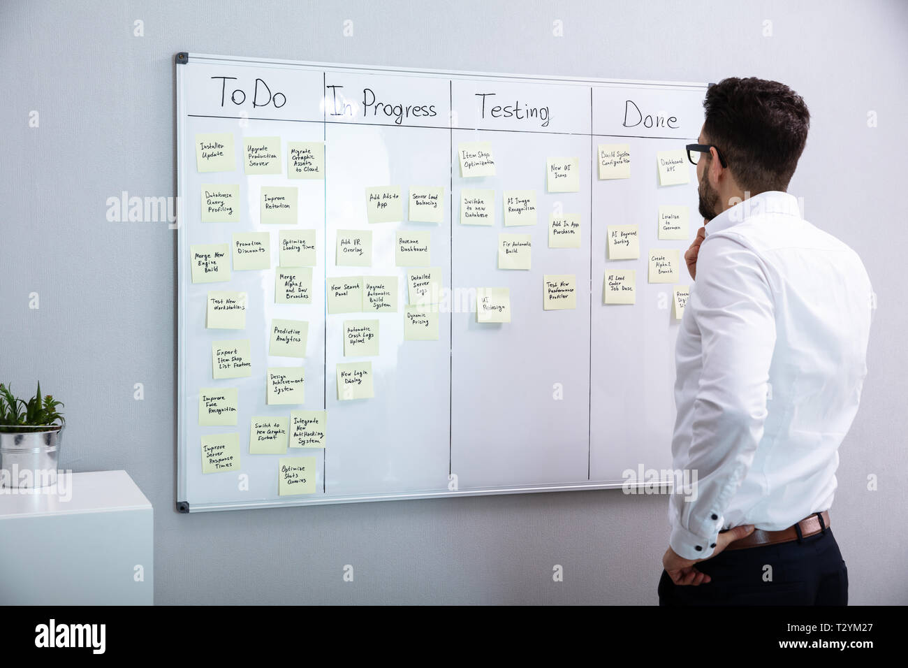 Ansicht der Rückseite des Geschäftsmann auf der Suche nach Haftnotizen auf dem Whiteboard Stockfoto