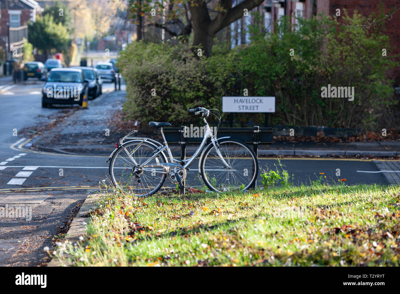 Lady's Fahrrad angekettet an ein Schild auf einer Vorstadtstraße im Broomhall, Sheffield Stockfoto