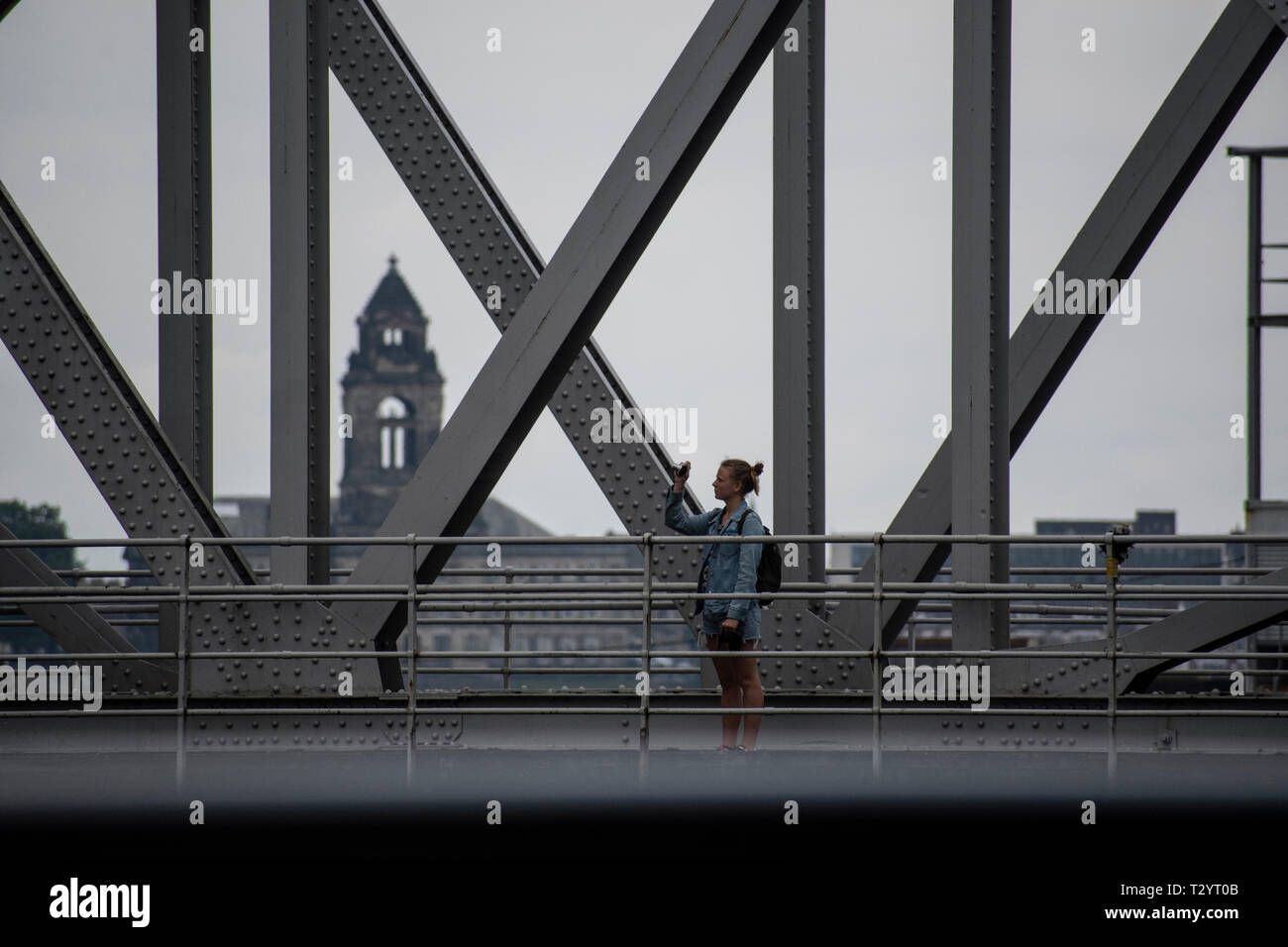 Junge Frau, die ein Foto auf der Stanley Dock Bascule Bridge, Liverpool Stockfoto