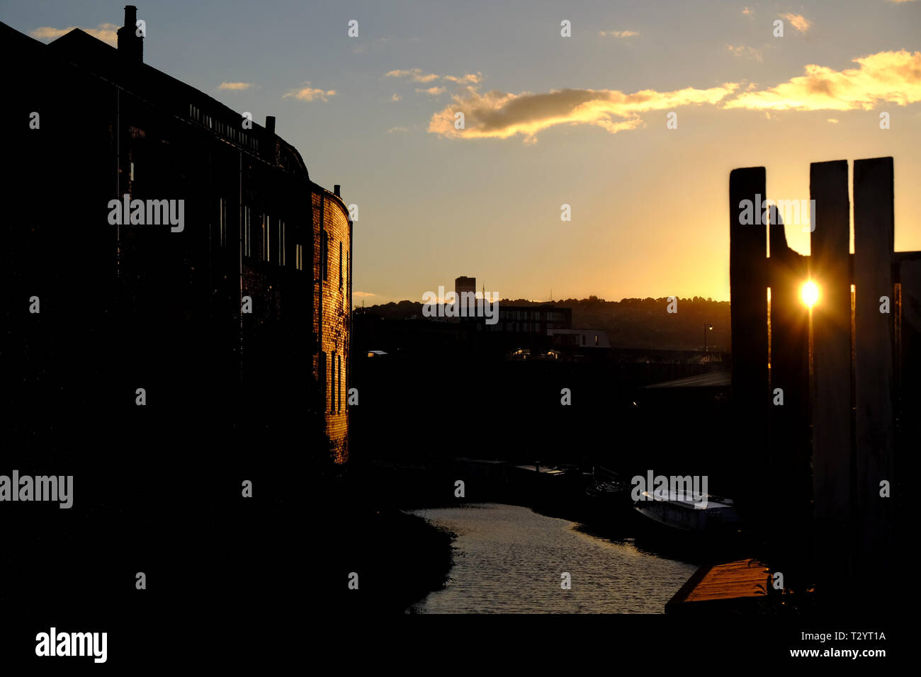 Sonnenuntergang über Sheffield Kanalbecken, mit alten Backsteinlagern auf der linken Seite Stockfoto