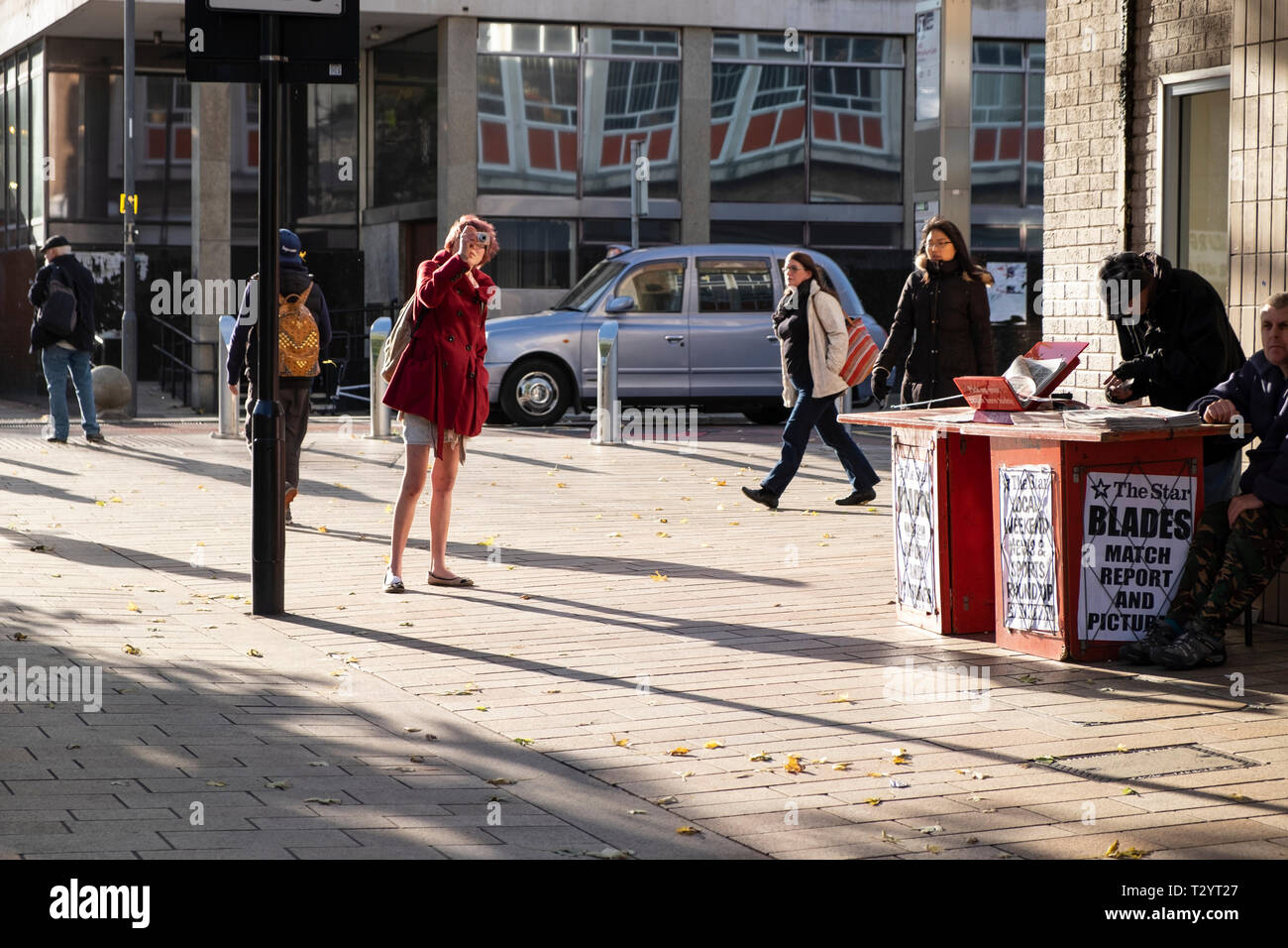 Junge Frau ein Foto auf einer Fußgängerzone in Sheffield an einem sonnigen Wintertag Stockfoto