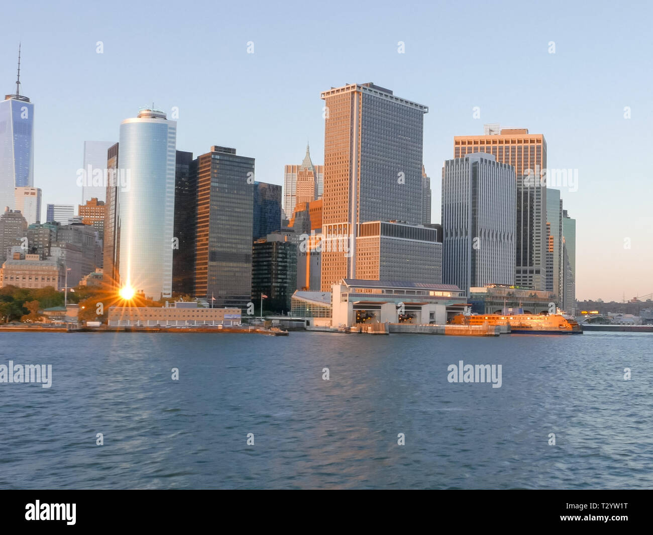 Die untergehende Sonne spiegelt die Wolkenkratzer an der Küste von Manhattan in New York Stockfoto