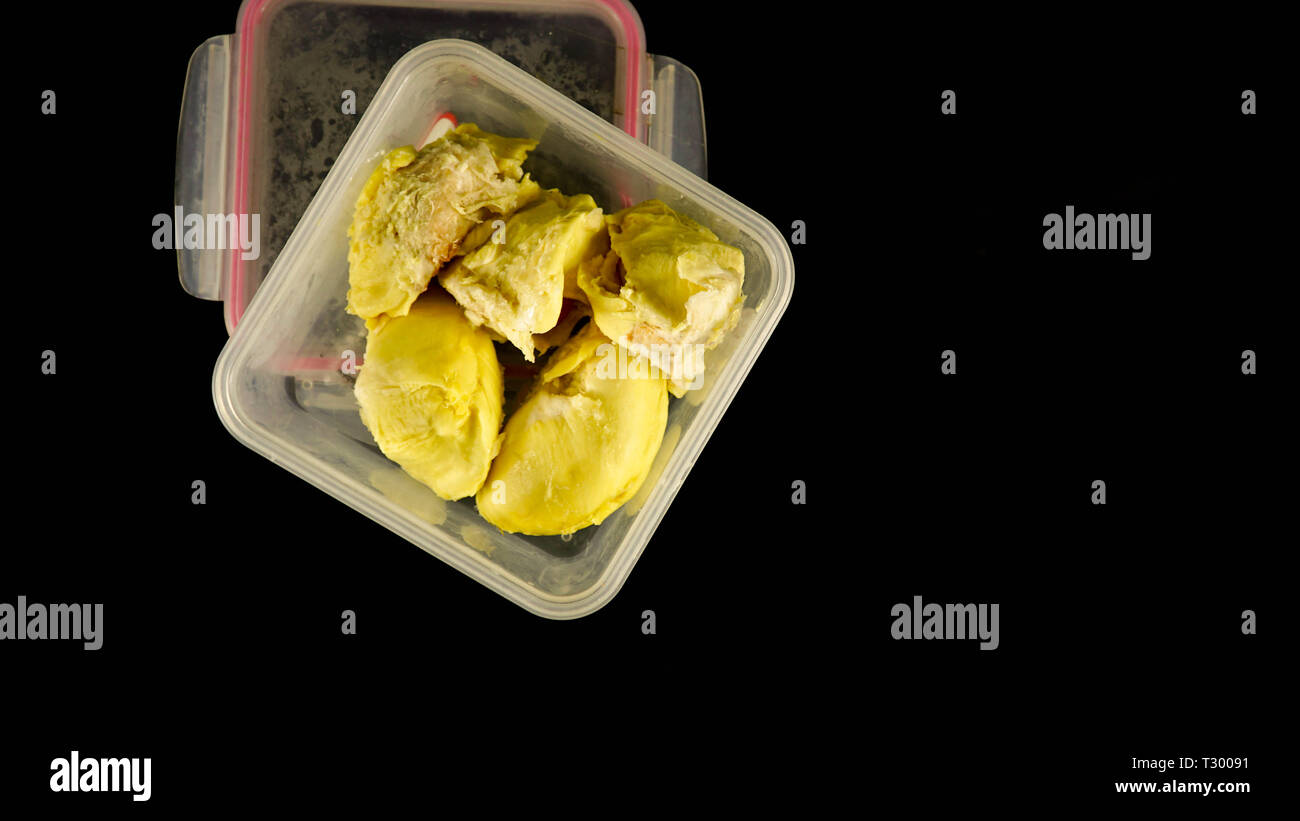 Nahaufnahme der cremige Durian Frucht in Kunststoffbehälter in Schwarz isoliert Stockfoto