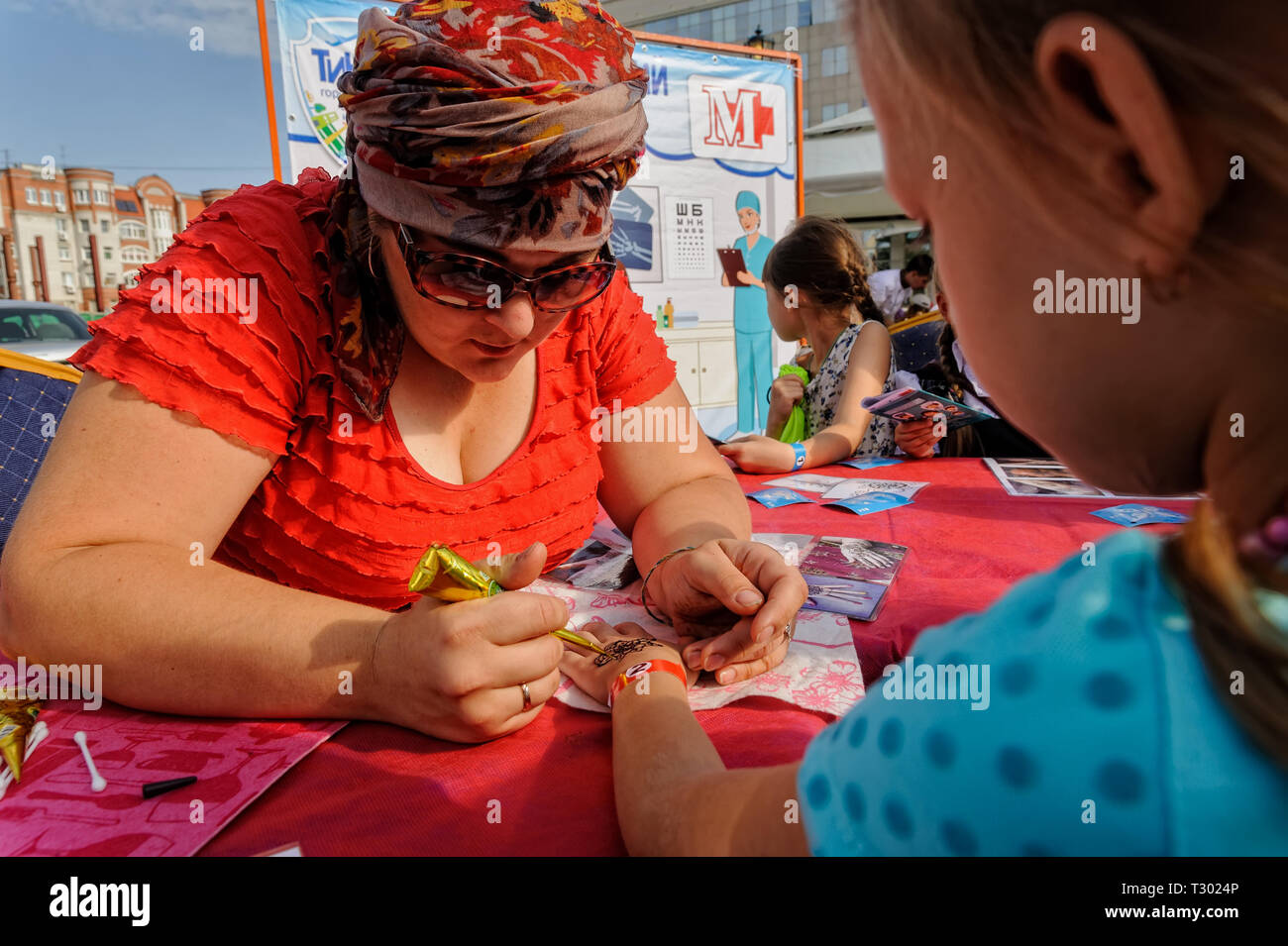 In Tjumen, Russland - 26. August 2016: Tag der offenen Tür der Sparkasse für Kinder. Kleines Mädchen, Glitter Tattoo an der Geburtstagsfeier Stockfoto