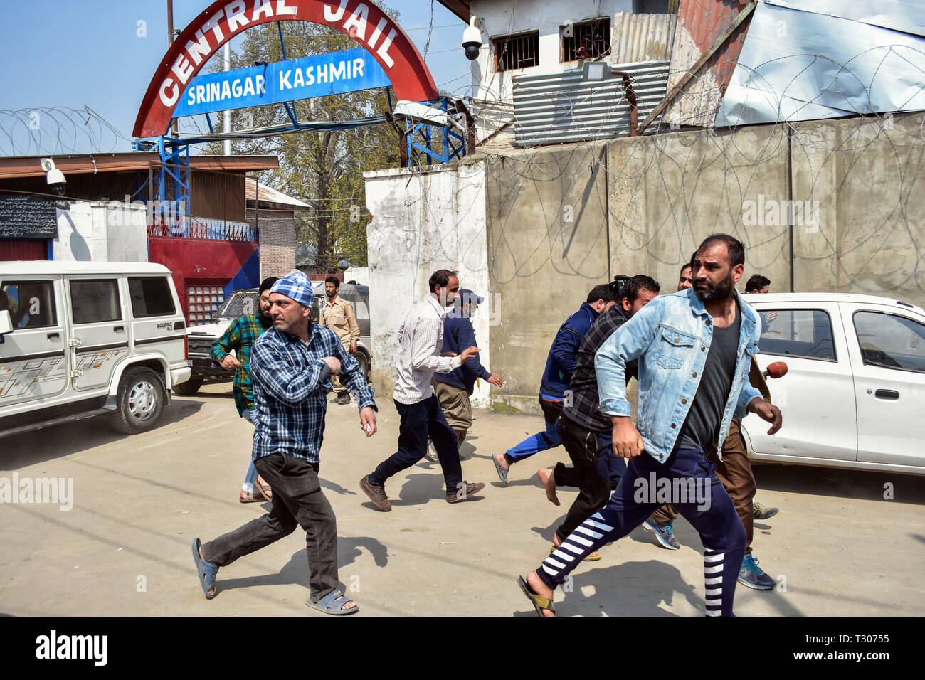 Angehörigen von Insassen gesehen laufen für Deckel als Polizei jagen Sie weg außerhalb der zentralen Gefängnis während der Riot breakout in Srinagar, Kashmir. Unruhen brachen im Inneren eine hohe Sicherheit zentrale Gefängnis in Srinagar, nachdem Gerüchte von Gefangenen aus dem Kaschmir-tal verschoben werden. Inzwischen haben die Behörden ausgesetzt haben, Internet und auferlegten Beschränkungen in der Altstadt von Dubrovnik. Stockfoto