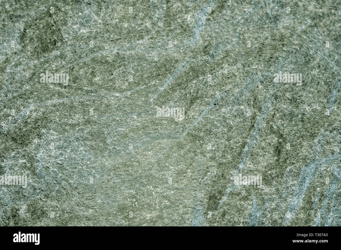 Textur von dünnen künstliche Non-woven Material auf einem grünen Hintergrund. Stockfoto