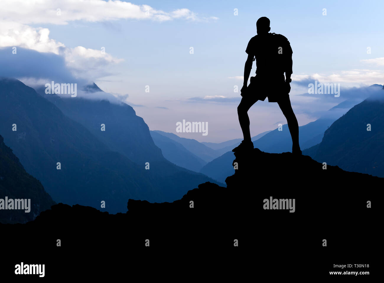 Mann auf erfolgreiche Wandern, Silhouette in Berge. Wanderer auf dem Berg mit Blick auf schöne Landschaft bei Sonnenuntergang im Himalaya, Nepal. Stockfoto
