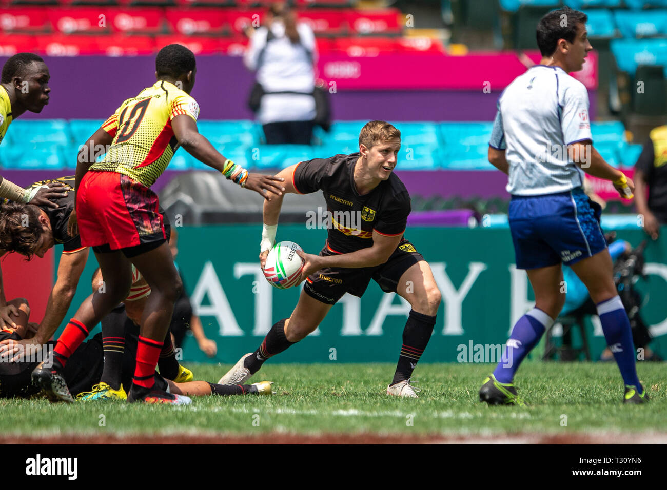 Hongkong, China. 05 Apr, 2019. Rugby Turnier am 05.04.2019 in Hongkong. Gruppenspiel Deutschland - Uganda: Deutschlands Kapitän Sam Rainger passt den Ball zu einem Team-mate. Auf der linken Seite, Joseph Aredo Jadwong (Uganda, 10) lauert für einen Fehler, der durch die Deutsche Mannschaft. Credit: Jürgen Kessler/Enterpress/dpa/Alamy leben Nachrichten Stockfoto