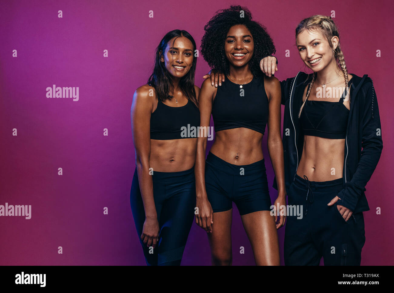 Multi-ethnischen fitness Frauen gemeinsam gegen farbigen Hintergrund. Vielfältige Gruppe Frauen in Sportswear nach dem Workout. Stockfoto