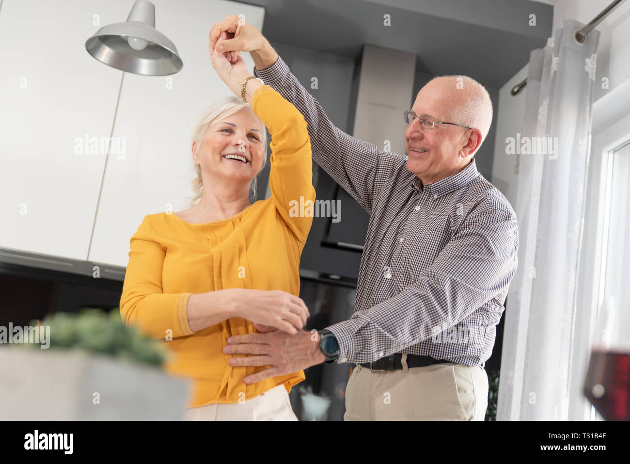 Senior Paar tanzen und zu Hause ein Lächeln auf den Lippen. Glückliches Paar der Rentner Stockfoto