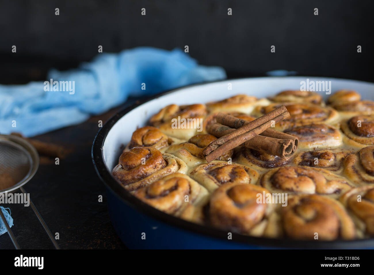 Cinnamon Roll Tarte mit Zuckersirup in vintage Backblech auf schwarzem Hintergrund Stockfoto