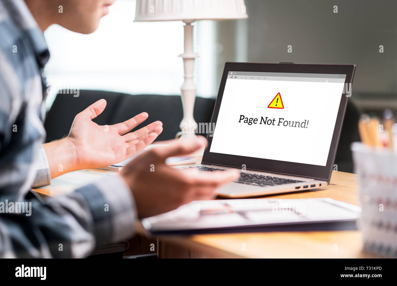 Seite nicht gefunden und Fehler im Laptop. Schlechte oder langsame Internetverbindung. Frustrierter mann Verbreitung Hände im Home Office. Defekter Computer funktioniert nicht. Stockfoto