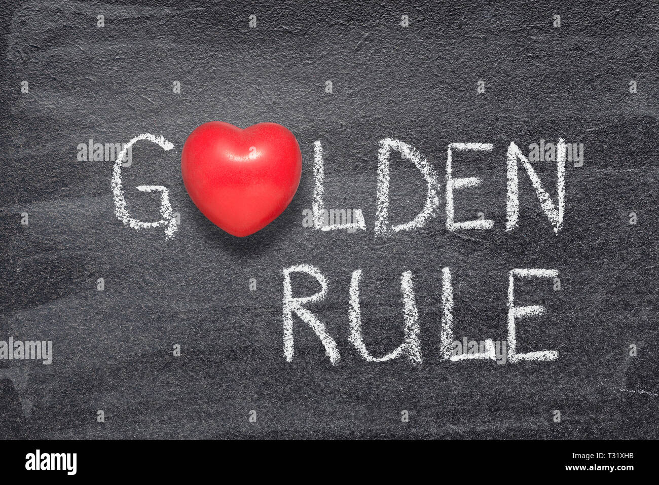 Goldene Regel Phrase handgeschrieben auf Schiefertafel mit roten Herzen Symbol anstelle von O Stockfoto