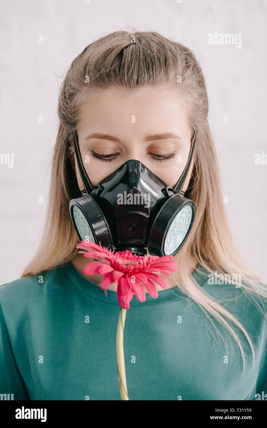 Blonde Frau mit Pollen Allergie tragen Atemschutzmaske und Rosa Gerbera  Blume Stockfotografie - Alamy