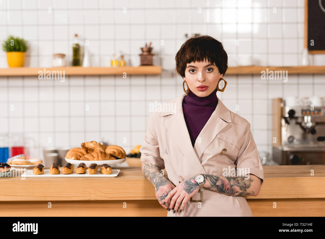 Schöne Geschäftsfrau steht in der Nähe der Theke in der Cafeteria und Kamera Stockfoto