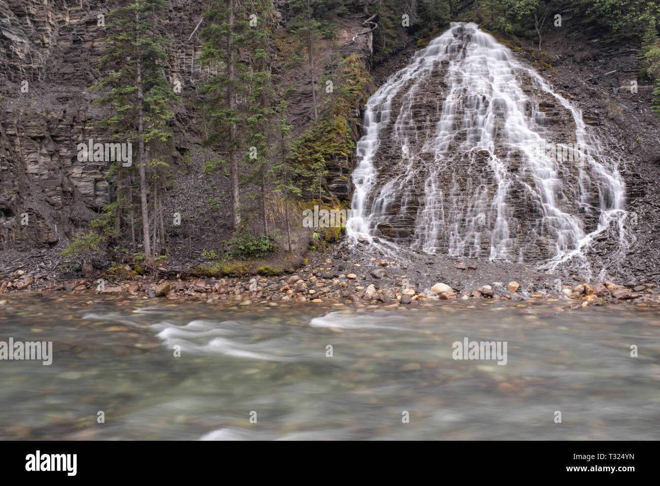 Ein Wasserfall stürzt in den Fluss entlang der Maligne Canyon, Jasper National Park, Kanada, auf einer langen Belichtungszeit. Stockfoto