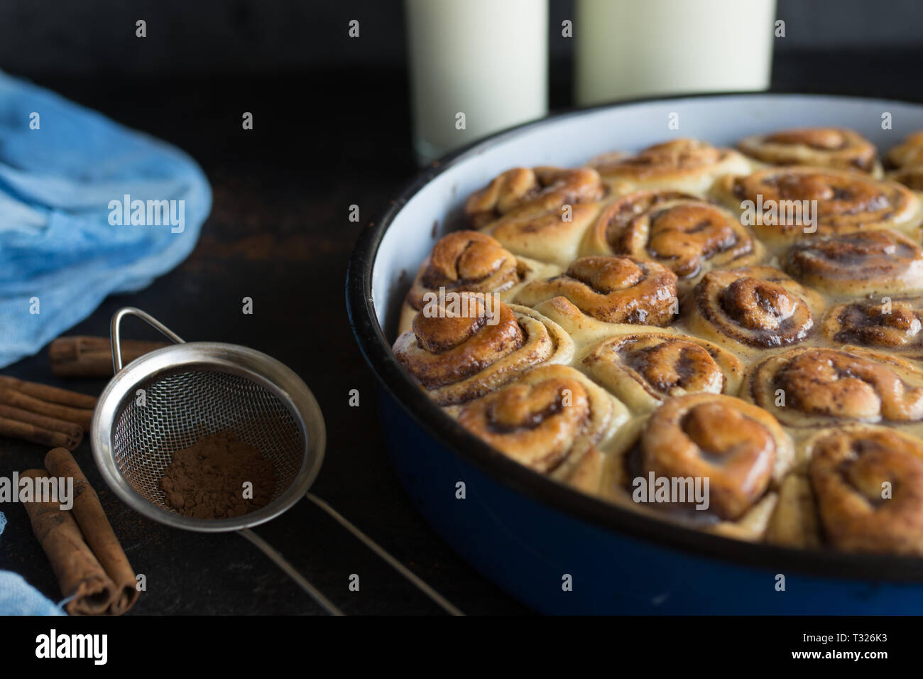 Cinnamon Roll Tarte mit Zuckersirup in vintage Backblech auf schwarzem Hintergrund Stockfoto