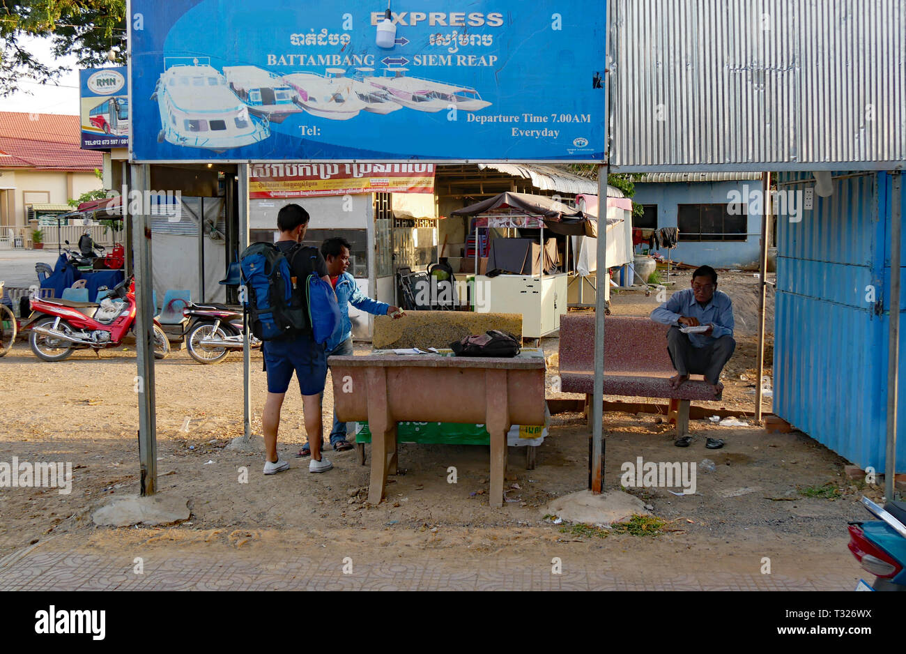 In Battambang, Kambodscha. Das Ticket für die Fähre von Battambang nach Siem Reap. In den frühen Morgenstunden und ein Backpacker kauft sein Ticket nach Siem Reap Stockfoto