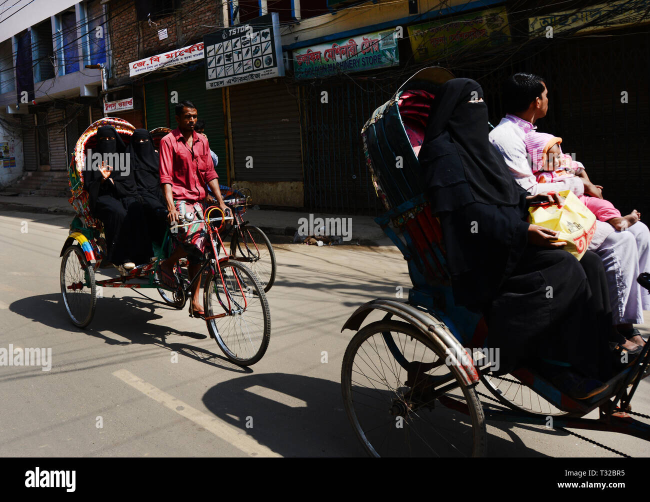 Verschleierte Frauen reiten auf einem Zyklus Rikscha in Dhaka, Bangladesh. Stockfoto