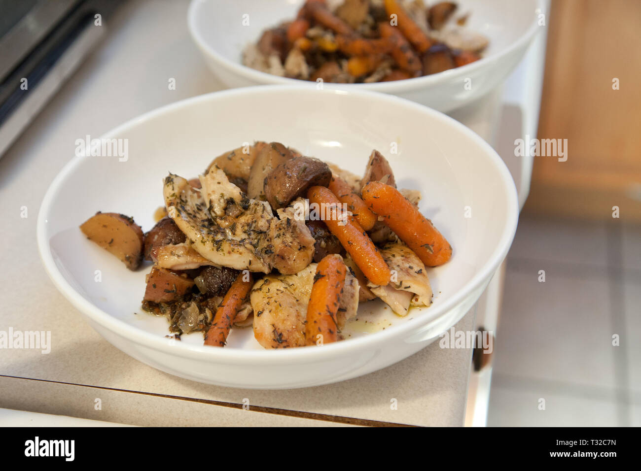 Zwei weiße Platten frischen hausgemachten Hühnereintopf bereit, um bedient zu werden. Stockfoto