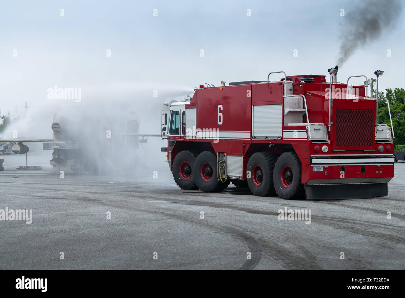 Eine P-23 Flugzeuge Rettung und Brandbekämpfung crash Lkw spritzt Wasser auf einem Training Flugzeug während einer Übung, April 3, 2019, bei Kadena Air Base, Japan. Die P-23 Crash Lkw ist die größere Version des P-19 ARFF Lkw und hat einen größeren Brandschutzmittel Kapazität. Es ist in erster Linie für Transport, Bomber, Depot- und Cargo Aircraft Basen zugeordnet. (U.S. Air Force Foto von Airman 1st Class Matthew Seefeldt) Stockfoto