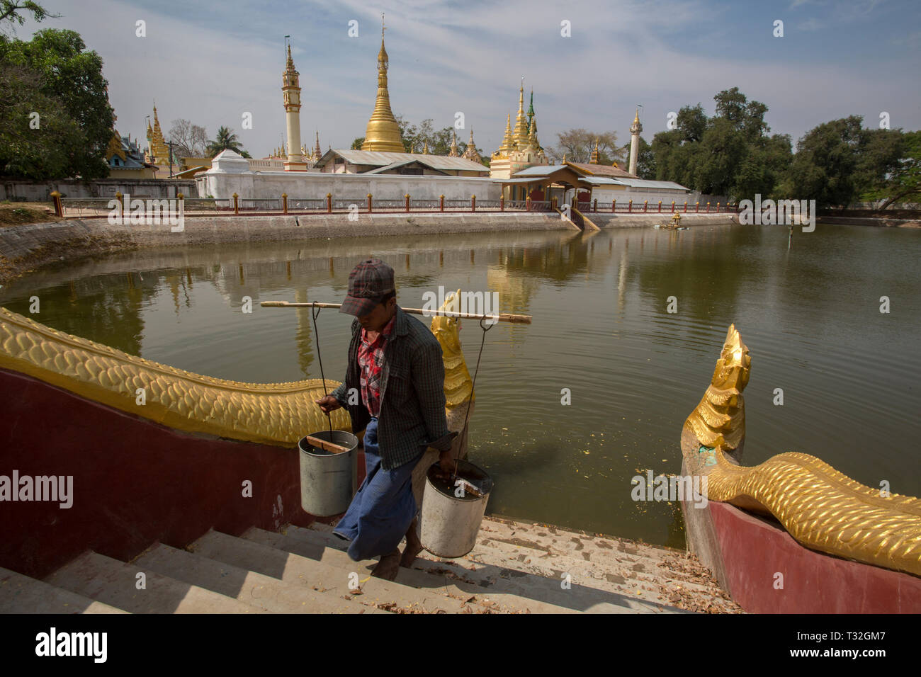 Wasser sammeln von Wasser aus einem kleinen See neben Shwe Yin Maw Pagode in der Nähe von Thazi, Myanmar (Birma). Stockfoto