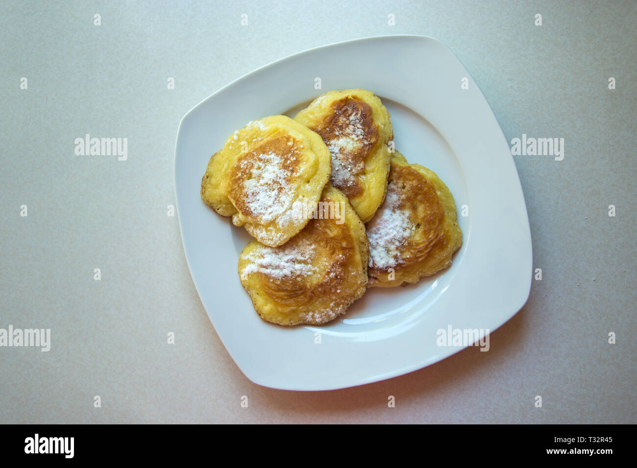 Traditionelle polnische Pfannkuchen auf einer Platte - Süße Pfannkuchen mit Puderzucker bestreut Stockfoto