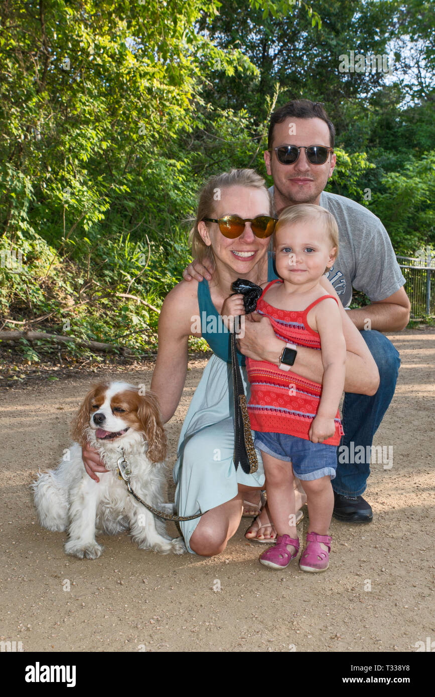 Vater, Mutter, Mädchen Kleinkinder- und Cavalier King Charles Spaniel, am Kellermeister Trail im Zilker Park in Austin, Texas, USA Stockfoto