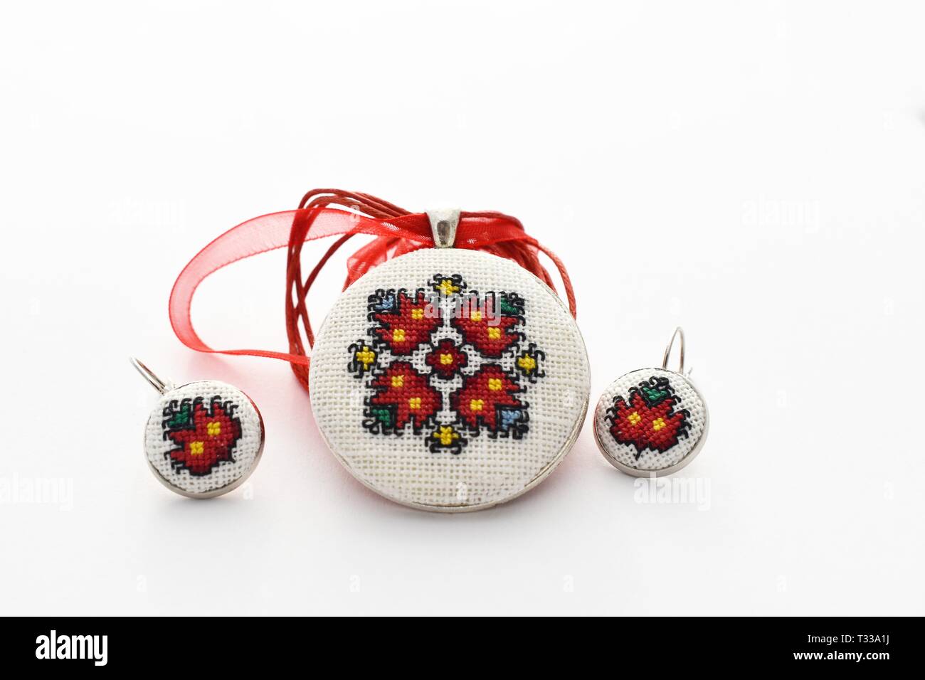 Handmade Cross Stitch Schmuck Set rote Blumen bestickt auf der weißen Leinwand Stockfoto